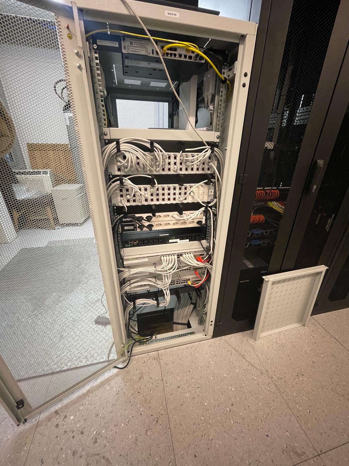 Vue d'ensemble d'une baie LAN raccordée dans un local informatique